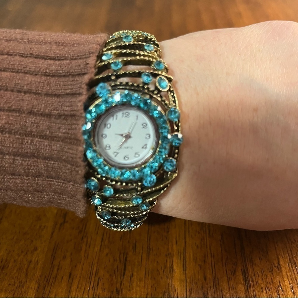 Perennial Quartz aqua rhinestone gold tone watch.